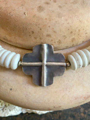 A mid-length white howlite and silver necklace crafted crafted from natural heshi cut beads, with a handmade sterling silver cross centrepiece and antique Indian silver beads. Finished with sterling silver ends and hook clasp. Total length 51.8 cm, pendant 2.5 cm diameter