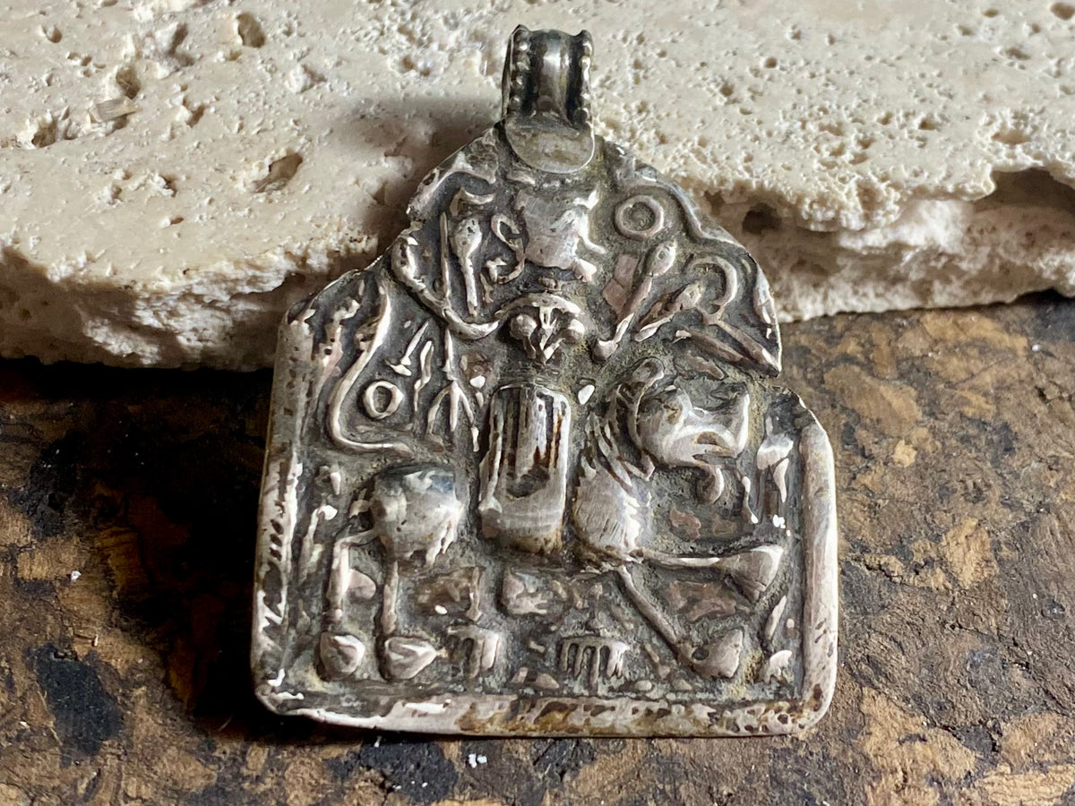 This large Durga&nbsp;amulet &nbsp;dates to the early 20th century, the bail has been replaced at some stage as it most likely wore through. Lightweight and easy to wear, this is a beautiful amulet.  Measurements: height 4.8 cm including bail, width 3.5 cm