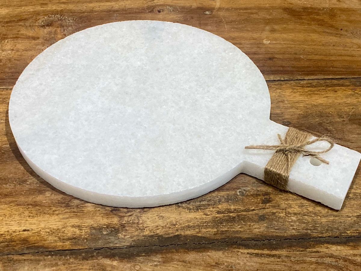 Our simple marble plate is designed for serving nibbles or for use as a cheeseboard. However, its simplicity means that it would also make a very nice plant or object stand. Hand carved in Rajasthan from white marble. A simple handle with hole for hanging completes the look. Measurements: length 29 cm, 21.5 cm disk diameter