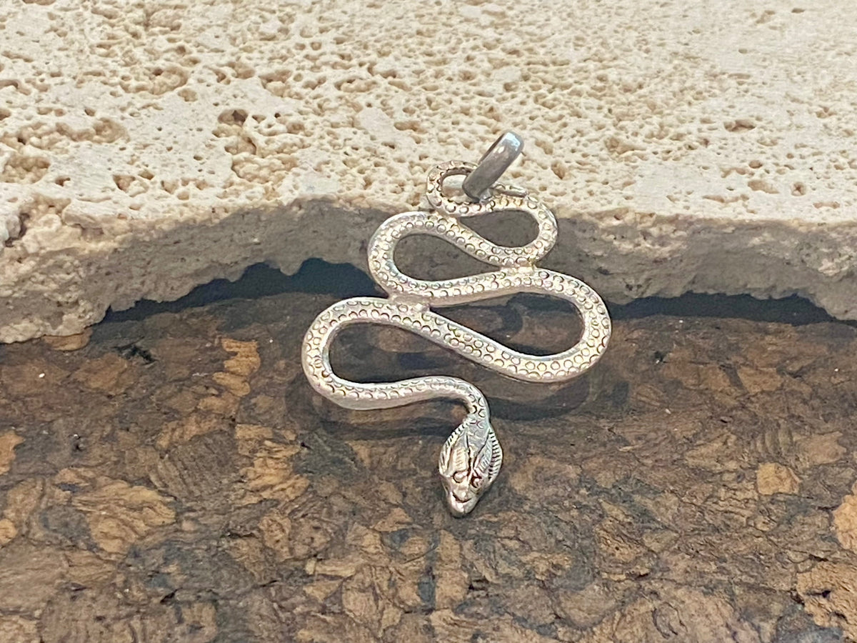 Hand cast snake pendants. Two styles. Sterling silver. Set with a wide bail capable of taking a sizeable chain or cord. Our unisex snake pendants are from Nepal.&nbsp;