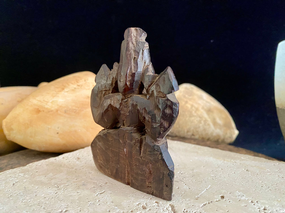 Small rosewood carving of Ganesh. Early 1900's, from east India. Two arms, seated, with his trunk to the left.  Height 9.5 cm, width  7 cm