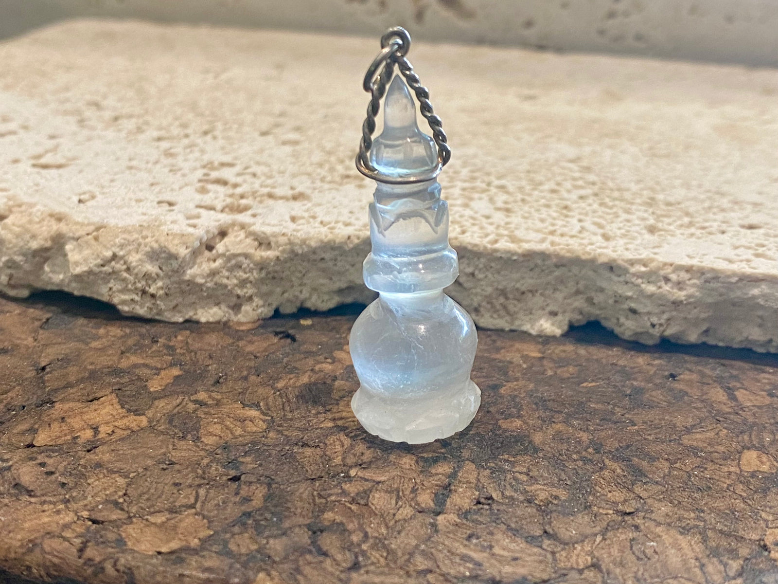 Hand carved rock crystal featuring the Buddhist stupa. Sterling silver bail. A stunning unisex pendant, would look beautiful on anyone.   Measurements: length including bail 4.7 cm, width 1.7 cm