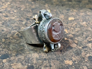 Afghani ring features a large carnelian stone carved with the images of two birds. Medallions of brass, silver loops and an embossed band complete the decoration. This large silver ring sits high on the finger and is statement jewellery. Adjustable ring, inner diameter 18 mm | Size 7.75 | No 17