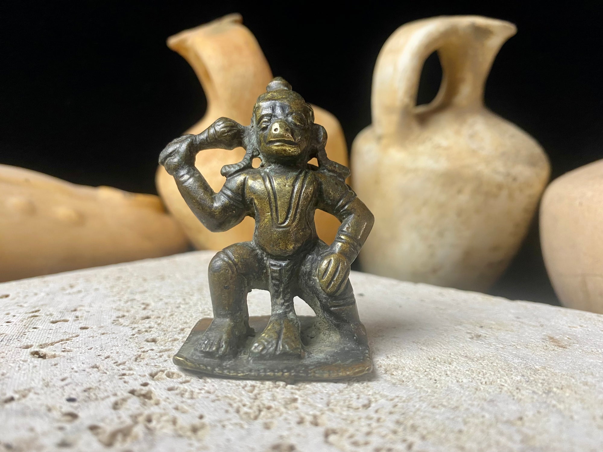 A small cast brass Hanuman in forward kneeling style. This piece has some rubbing on the face, shows a naturally darkened patina and is approximately 80 years old, although it may be older. Gujarat, India. Measurements: height 6 cm