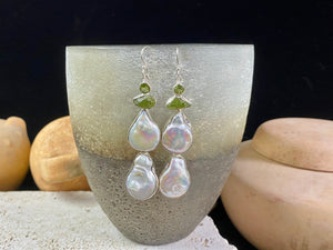Very long earrings featuring cultured baroque pearls and peridot stones. These statement earrings are set in sterling silver, with sterling silver shepherd hooks. 8 cm length including hooks, width approximately 1.8 cm, depth 0.5 cm