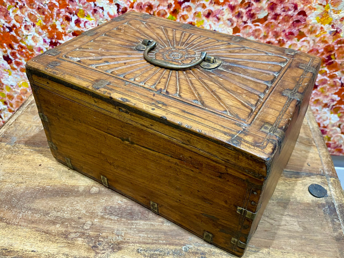 A lovely old southern Indian cash box with carved top and original brass trim, handle and hinges. Fitted with two small shelves inside. Made from teak, this would make a lovely trinket box, key box, jewellery, watch or cufflink box Circa 1880 - 1920. Measurements: length 27.5 cm  x depth 19 cm, height 15 cm.