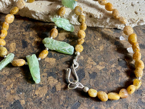 A polished pebble golden ocean jasper short necklace featuring spears of natural, unpolished green kyanite and sterling silver. Our necklace is finished with a sterling silver hook clasp and findings. Length 38 cm