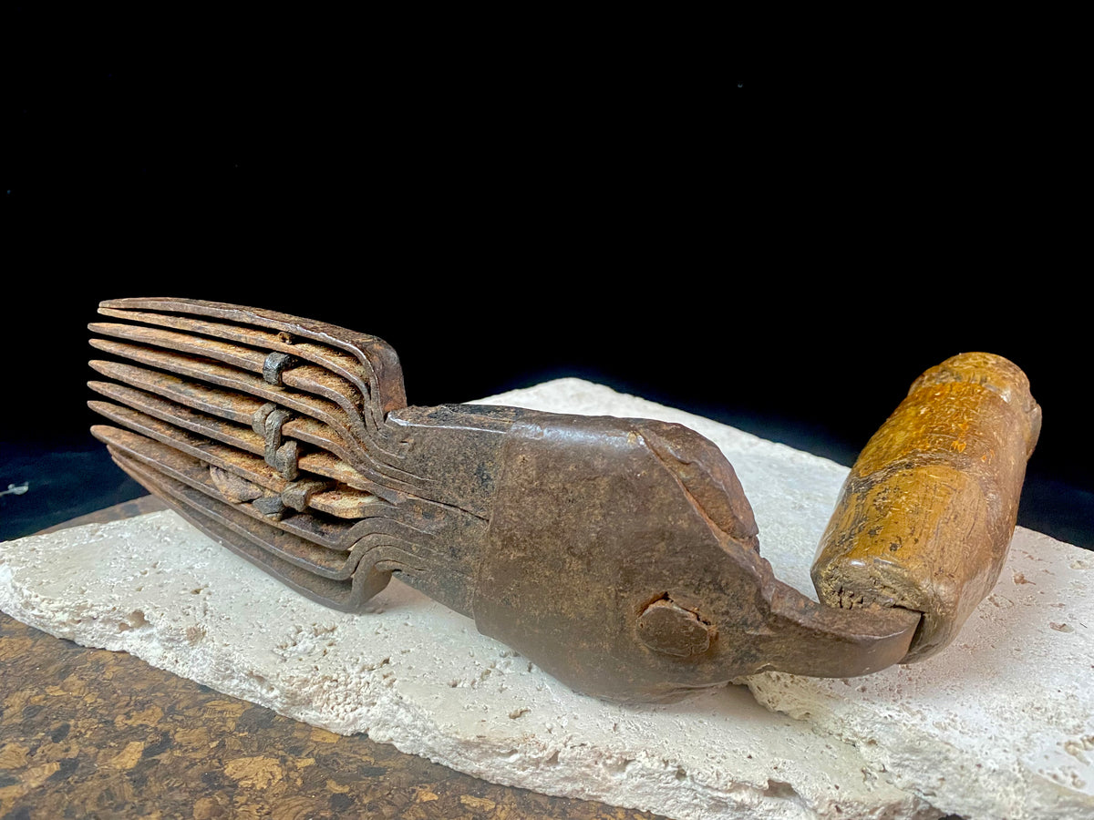 Used for the manual tamping down of carpet threads during the weaving process on a hand loom. Heavy iron with a wood handle. 19th century or older. Afghanistan.  Measurements: length 26 cm, width 6.5 cm, height 10 cm