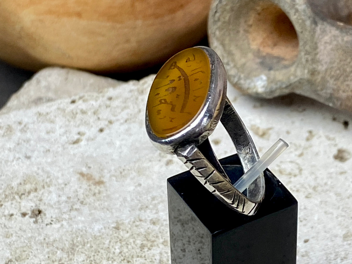 Afghani ring features an antique honey-coloured engraved carnelian prayer plaque set into a new silver band. Sits high on the finger and is a statement piece. High grade or sterling silver has been used to make the ring band. Men or women's ring. Measurements: Carnelian 2.4 x 1.4 cm, inner diameter 19.75 mm | Size 10