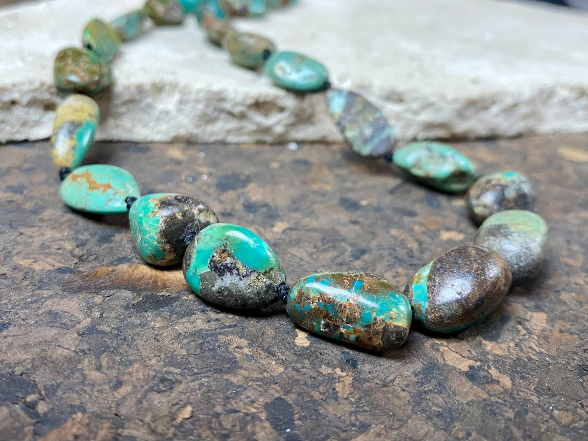 A necklace crafted from blue-green Tibetan turquoise, knotted between each bead in the traditional jewellery making technique of the region. Finished with sterling silver beads and hook clasp. Length 42 cm