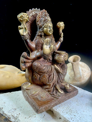 A statue of the goddess Laxmi (or Lakshmi), Hindu goddess of wealth and prosperity. Cast from solid brass, her features are exquisitely detailed, while her face, hands and feet are polished. Her right hand is raised in the gesture of protection and her left hand holds a pot symbolising abundance. Measurements: 19.8 cm height, width12 cm, depth 8.3 cm