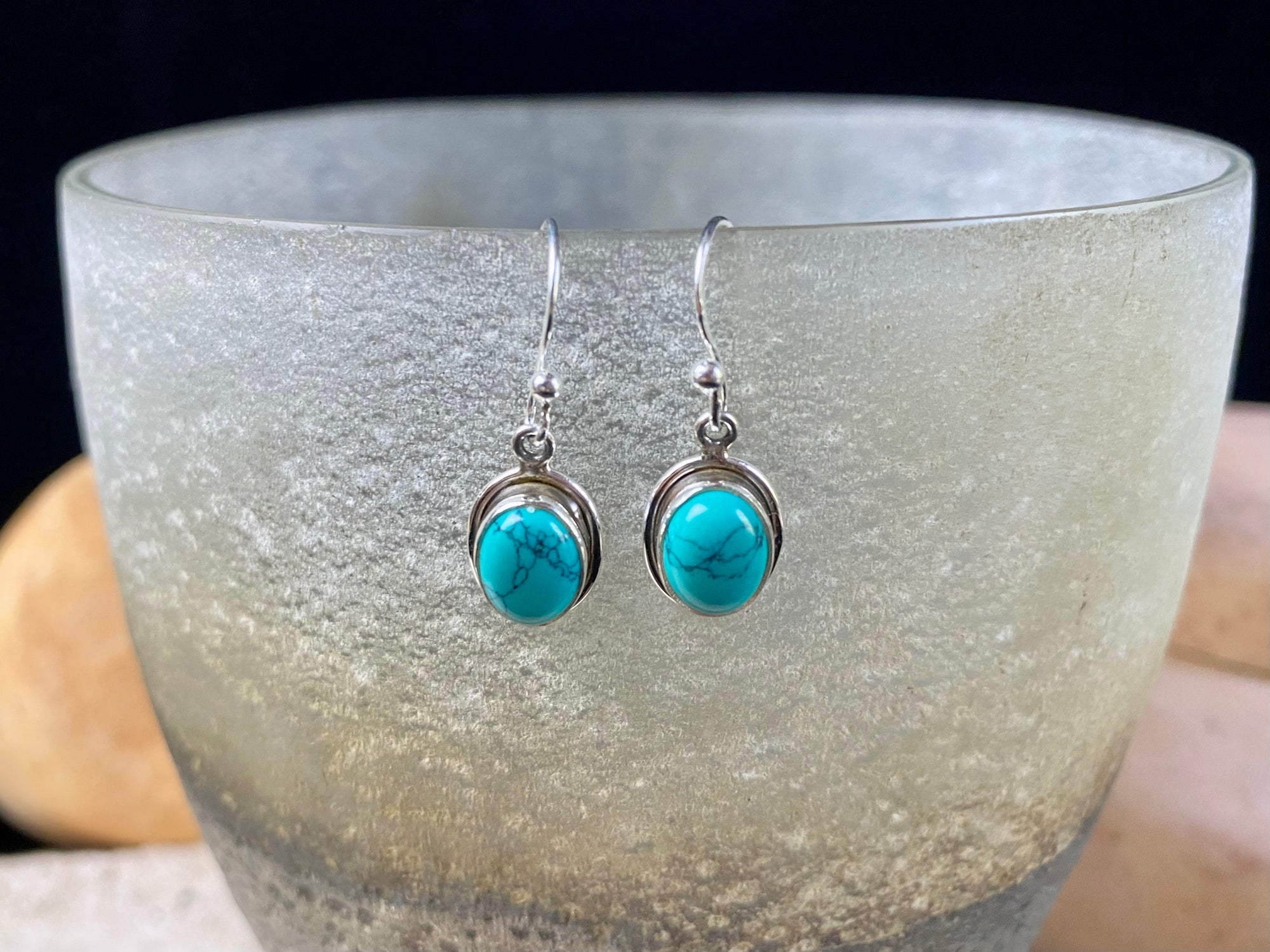 Simply elegant oval earrings with a small shadow box bezel to show off the beauty of the natural cabochon gemstones. Sterling silver hooks complete the look. Our earrings are open-backed to allow the light of the stones to show through. Length including hook 2.5 cm