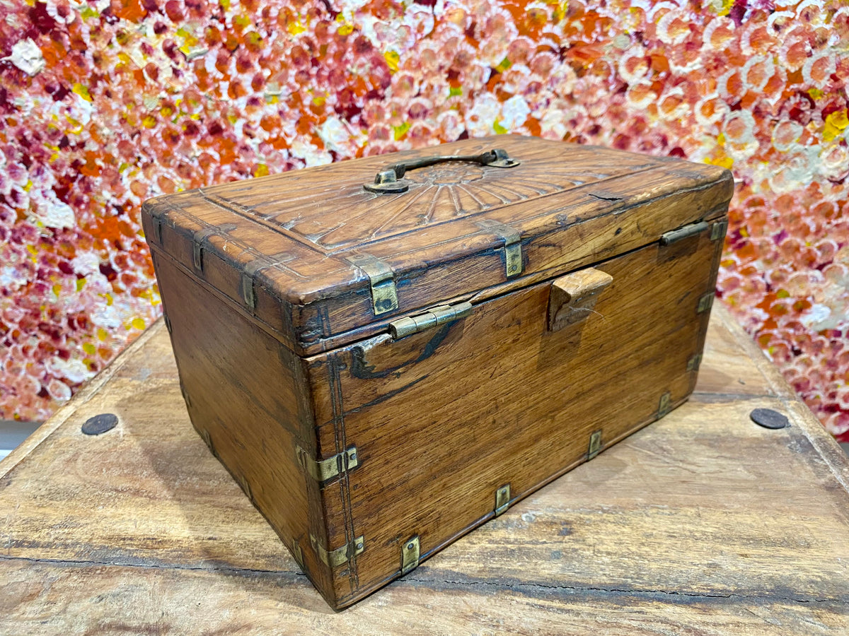 A lovely old southern Indian cash box with carved top and original brass trim, handle and hinges. Fitted with two small shelves inside. Made from teak, this would make a lovely trinket box, key box, jewellery, watch or cufflink box Circa 1880 - 1920. Measurements: length 27.5 cm  x depth 19 cm, height 15 cm.