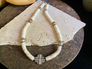 A mid-length white howlite and silver necklace crafted crafted from natural heshi cut beads, with a handmade sterling silver cross centrepiece and antique Indian silver beads. Finished with sterling silver ends and hook clasp. Total length 51.8 cm, pendant 2.5 cm diameter