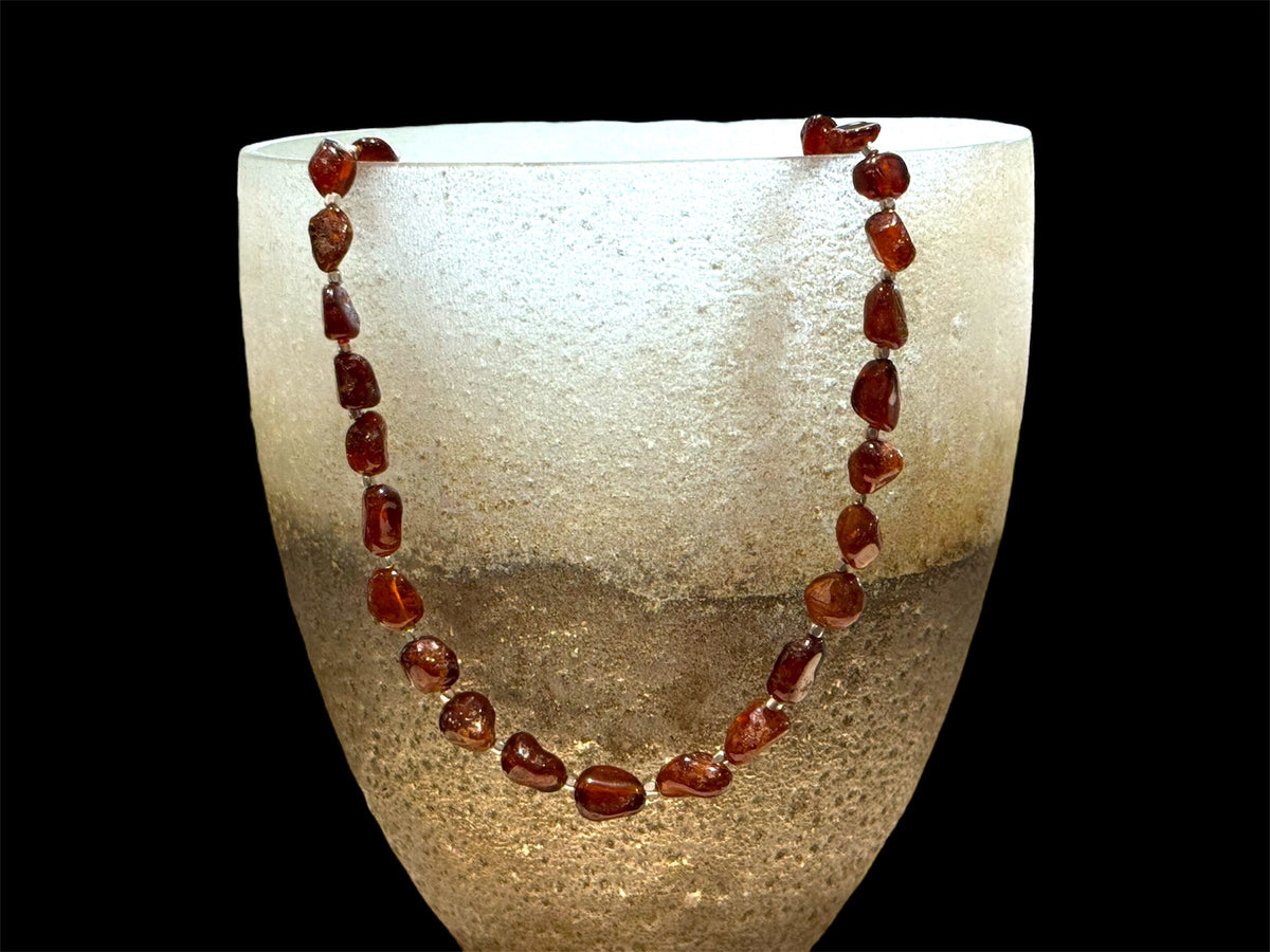 Cinnamon coloured, graduated hessonite garnet boulder beads, highlighted with sterling silver, finished with a silver hook clasp. Length 42 cm