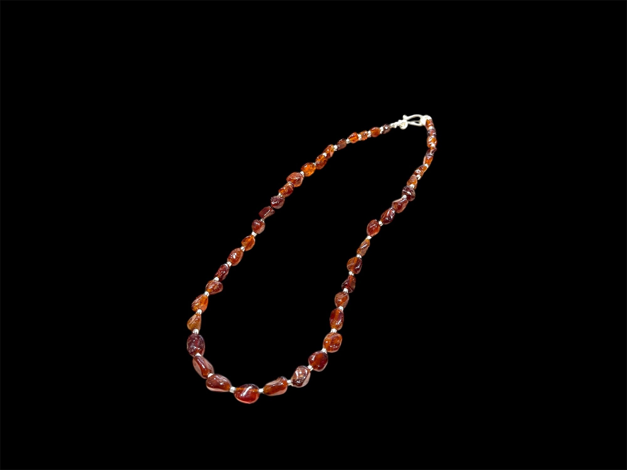 Cinnamon coloured, graduated hessonite garnet boulder beads, highlighted with sterling silver, finished with a silver hook clasp. Length 42 cm