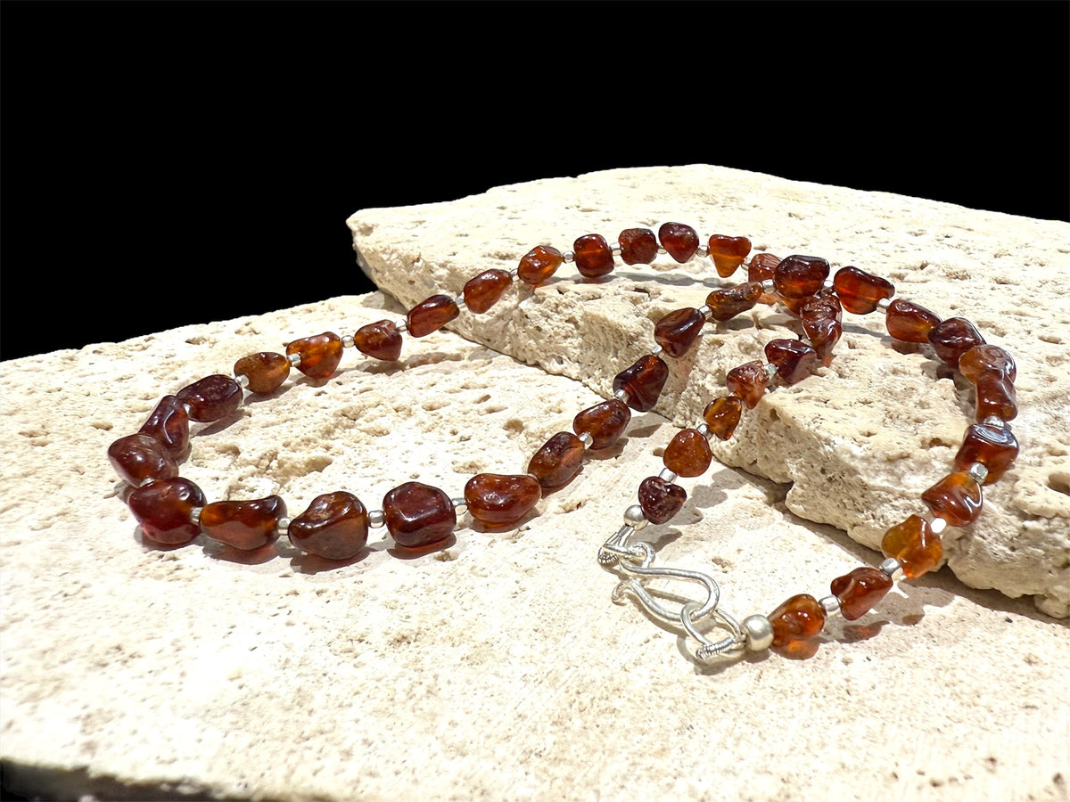Cinnamon coloured, graduated hessonite garnet boulder beads, highlighted with sterling silver, finished with a silver hook clasp. Length 42 cm