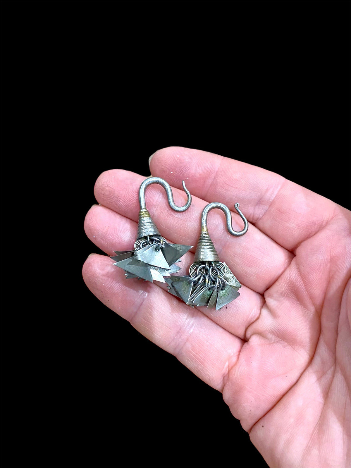 Golden Triangle Hmong silver earrings. Laos. Early 20th century. While the geometric dangles are a personal representation of taste, the inner part of the earring has the classic trilobate shape that mimics part of the poppy and other fruit.

Height 3.5 cm