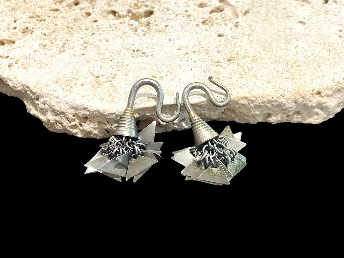 Golden Triangle Hmong silver earrings. Laos. Early 20th century. While the geometric dangles are a personal representation of taste, the inner part of the earring has the classic trilobate shape that mimics part of the poppy and other fruit.

Height 3.5 cm