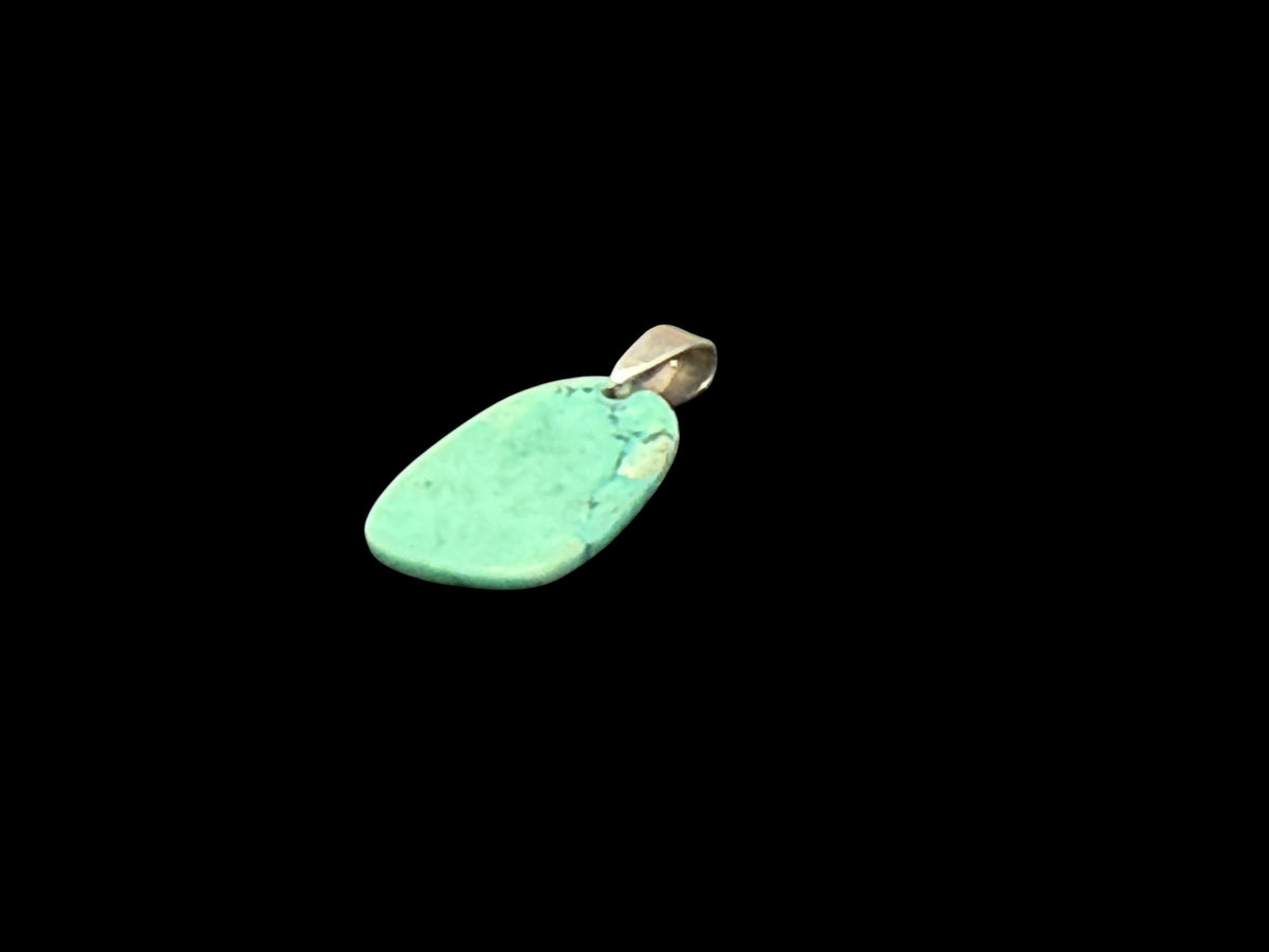 Simple but striking pendant made from a hand shape plate of turquoise-dyed howlite stone, with a sterling silver bail. Height including hook 2.8 cm