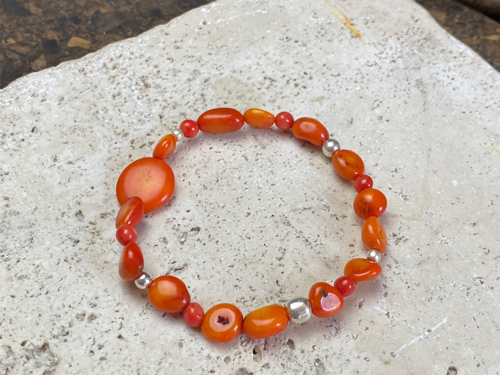 Charming bracelet made from Pacific deep sea bamboo coral in dark and light orange tones, finished with sterling silver. Elasticised cord for a seamless look.