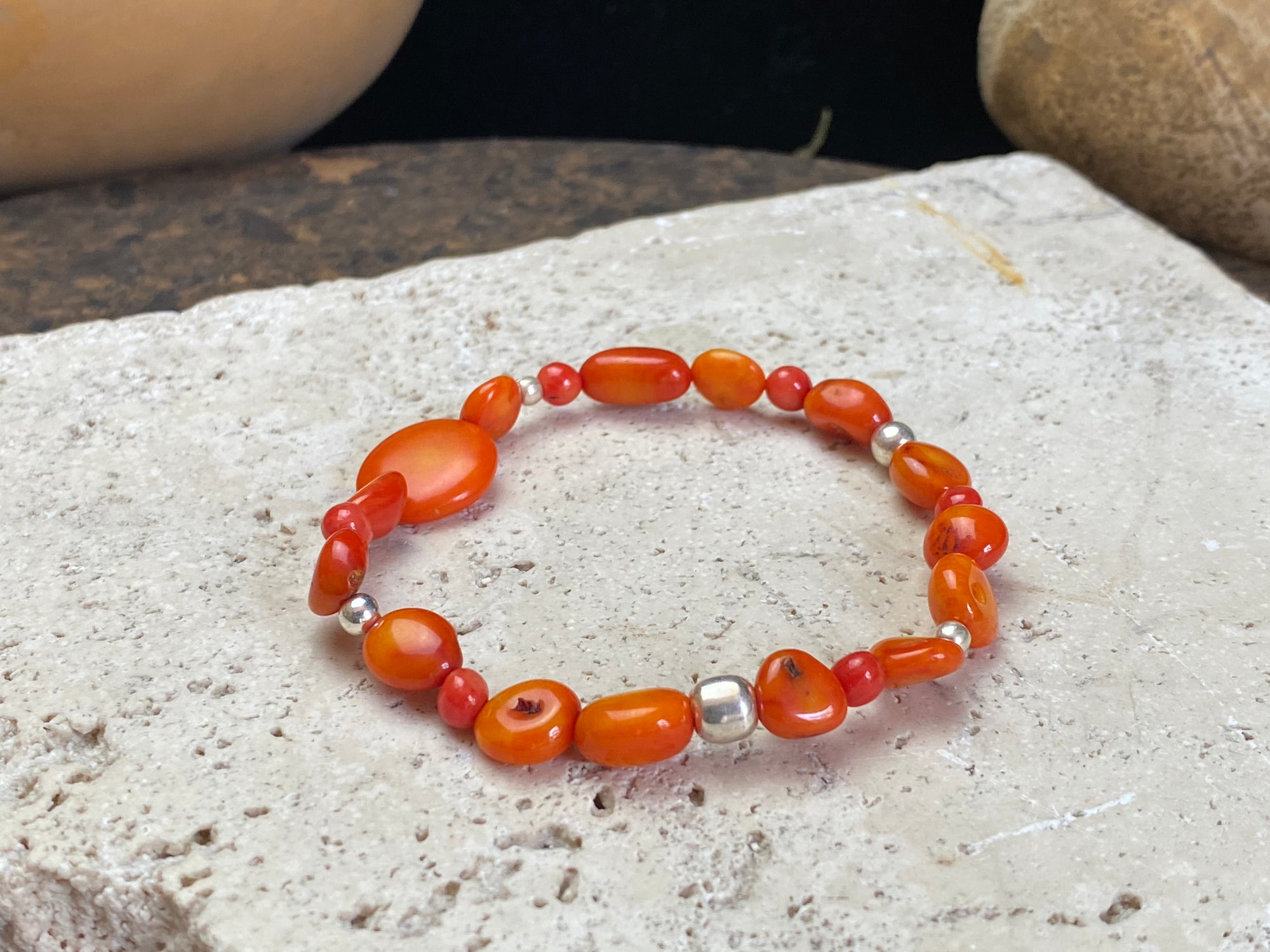 Charming bracelet made from Pacific deep sea bamboo coral in dark and light orange tones, finished with sterling silver. Elasticised cord for a seamless look.