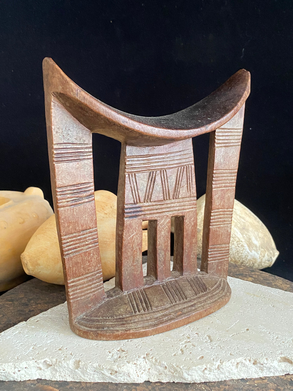 Old kambatta tribe wooden headrest from Ethiopia. Carved from a single piece of wood. Pre 1950. The patina and wear on this piece are appropriate to its age. In particular the upper surface is darkened from use. Measurements: height 18.5 cm