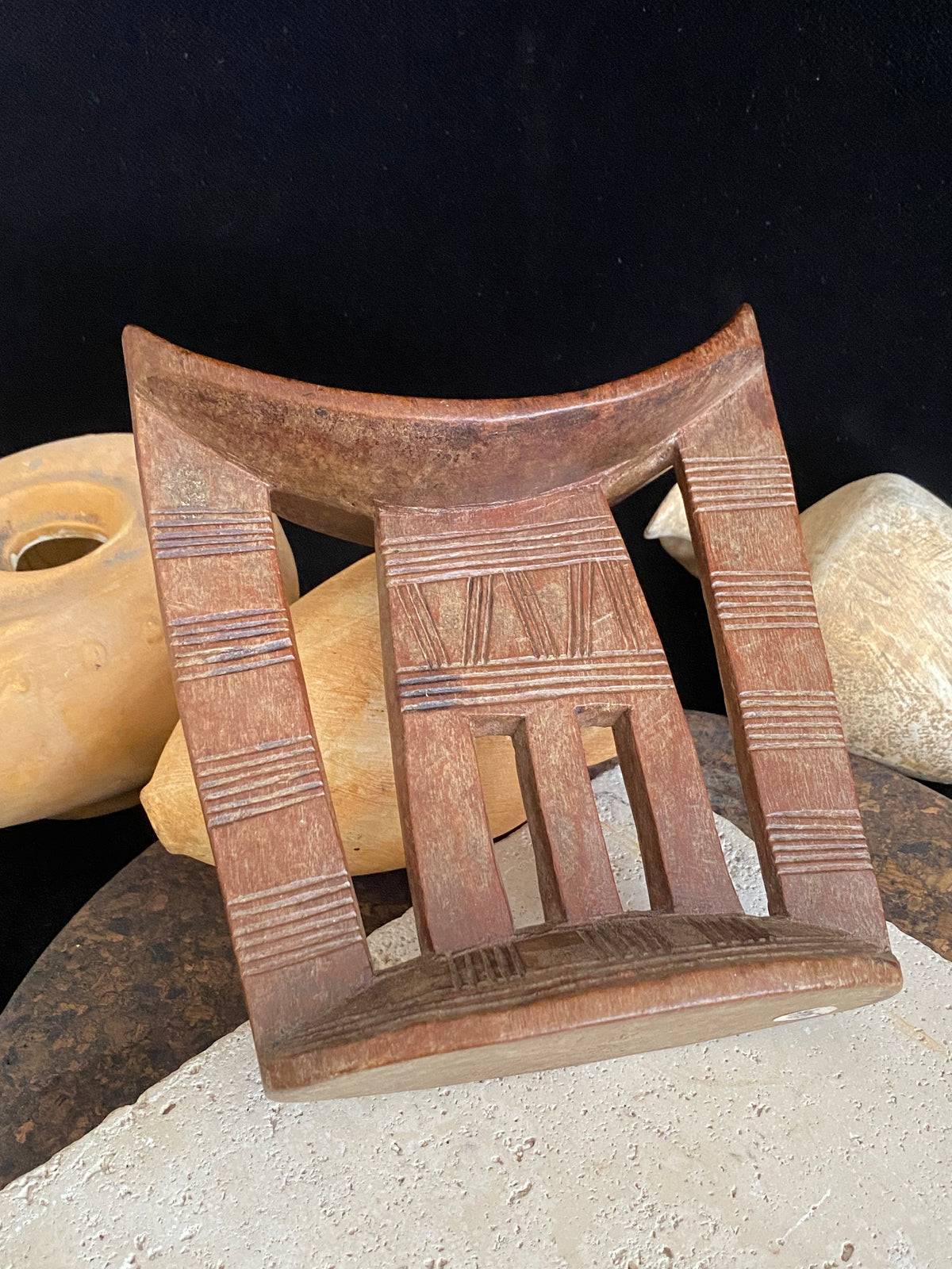 Old kambatta tribe wooden headrest from Ethiopia. Carved from a single piece of wood. Pre 1950. The patina and wear on this piece are appropriate to its age. In particular the upper surface is darkened from use. Measurements: height 18.5 cm