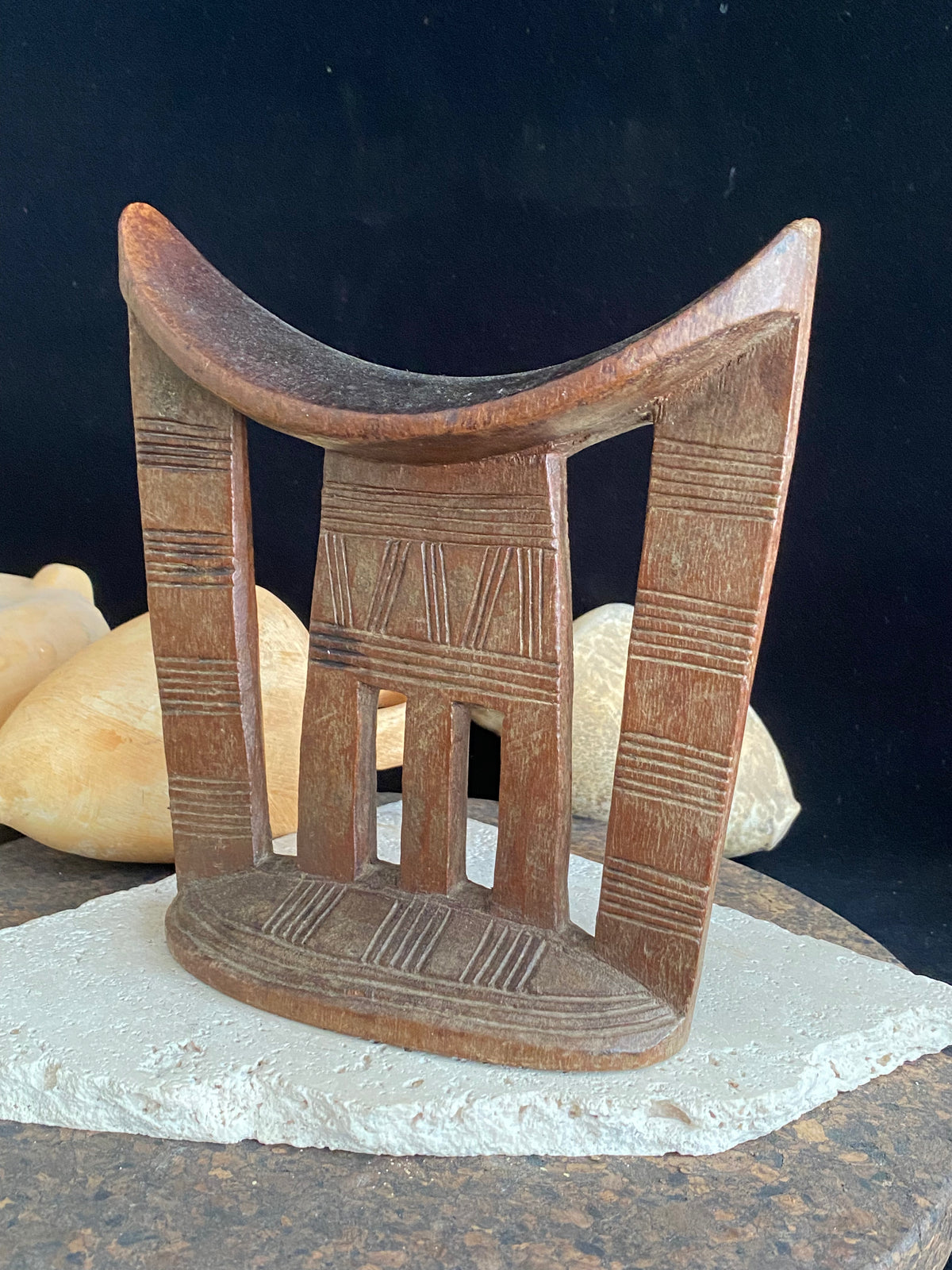 Old kambatta tribe wooden headrest from Ethiopia. Carved from a single piece of wood. Pre 1950. The patina and wear on this piece are appropriate to its age. In particular the upper surface is darkened from use. Measurements: height 18.5 cm