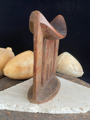 Old kambatta tribe wooden headrest from Ethiopia. Carved from a single piece of wood. Pre 1950. The patina and wear on this piece are appropriate to its age. In particular the upper surface is darkened from use. Measurements: height 18.5 cm