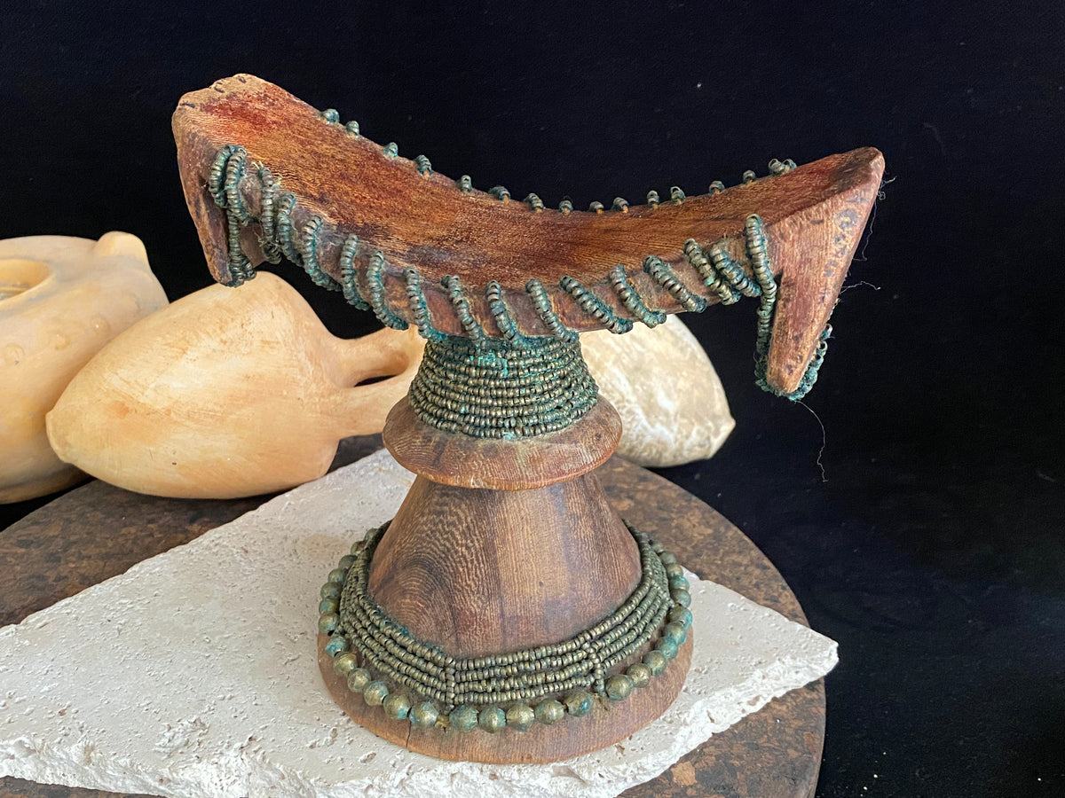Very old Oromo wooden headrest from Ethiopia. Carved from a single piece of wood, heavily beaded with green oxidation. Pre 1950. The patina and wear on this piece are appropriate to its age.  Measurements: height 16 cm, width 18 cm