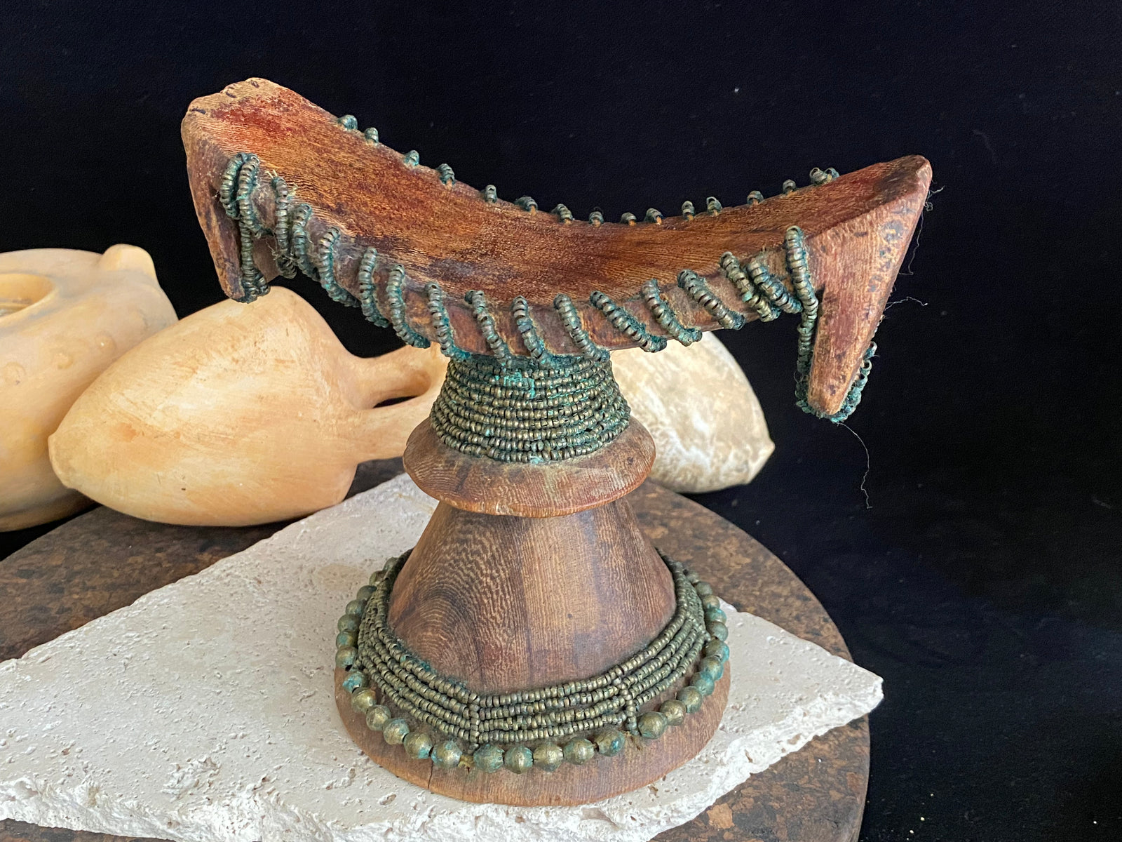 Very old Oromo wooden headrest from Ethiopia. Carved from a single piece of wood, heavily beaded with green oxidation. Pre 1950. The patina and wear on this piece are appropriate to its age.  Measurements: height 16 cm, width 18 cm