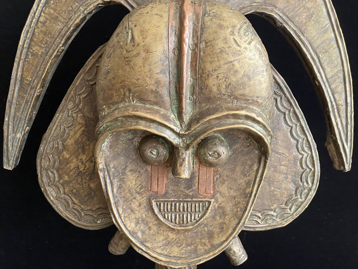 Mbulu-ngulu or funerary reliquary protective figure. Kota people, Gabon, West Africa. Mid to late 20th century. Wood with copper and brass decorative overlay. Height 54 cm, width at widest point 30 cm.