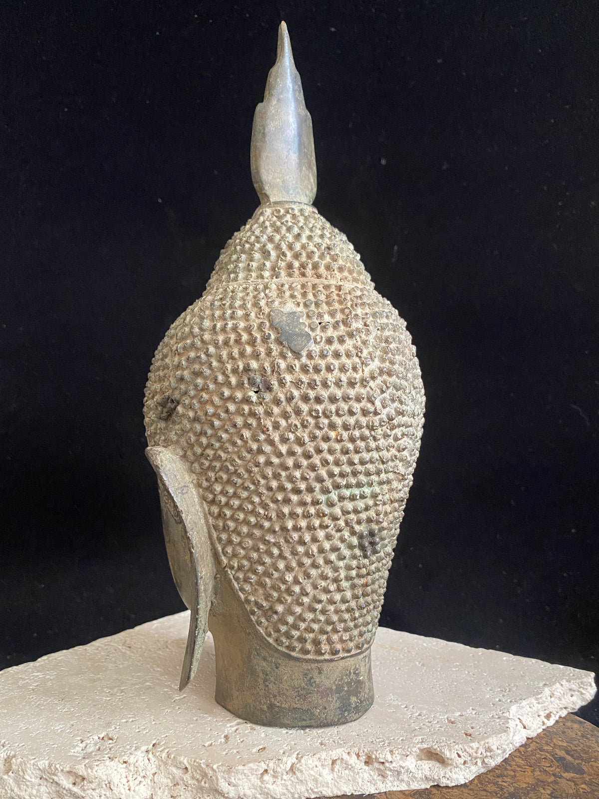 Thai Buddha head. Serene expression, hair topped with the flamed Ushnisha. Sukhothai style, bronze, mid 20th century. A softly contoured face with the bow shaped lips, prominent ears, arched eyebrows and aristocratic features typical of this style of work. Measurements: height 25 cm, width 11 cm