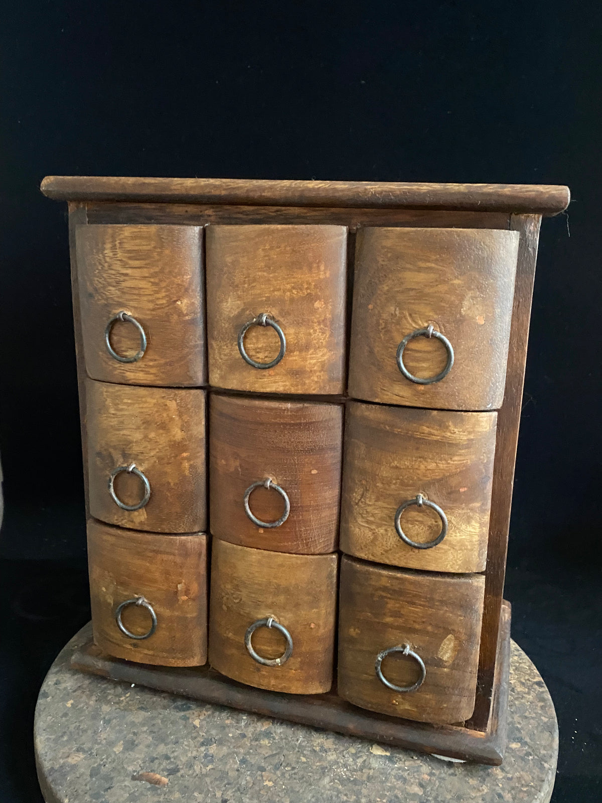 Simple curved face nine drawer cabinet trinket box. Made from solid Indian rosewood with iron rings as handles.  From Rajasthan, India. Made from Indian hard wood.  Height 28 cm, width 24.5 cm, depth 15.5 cm