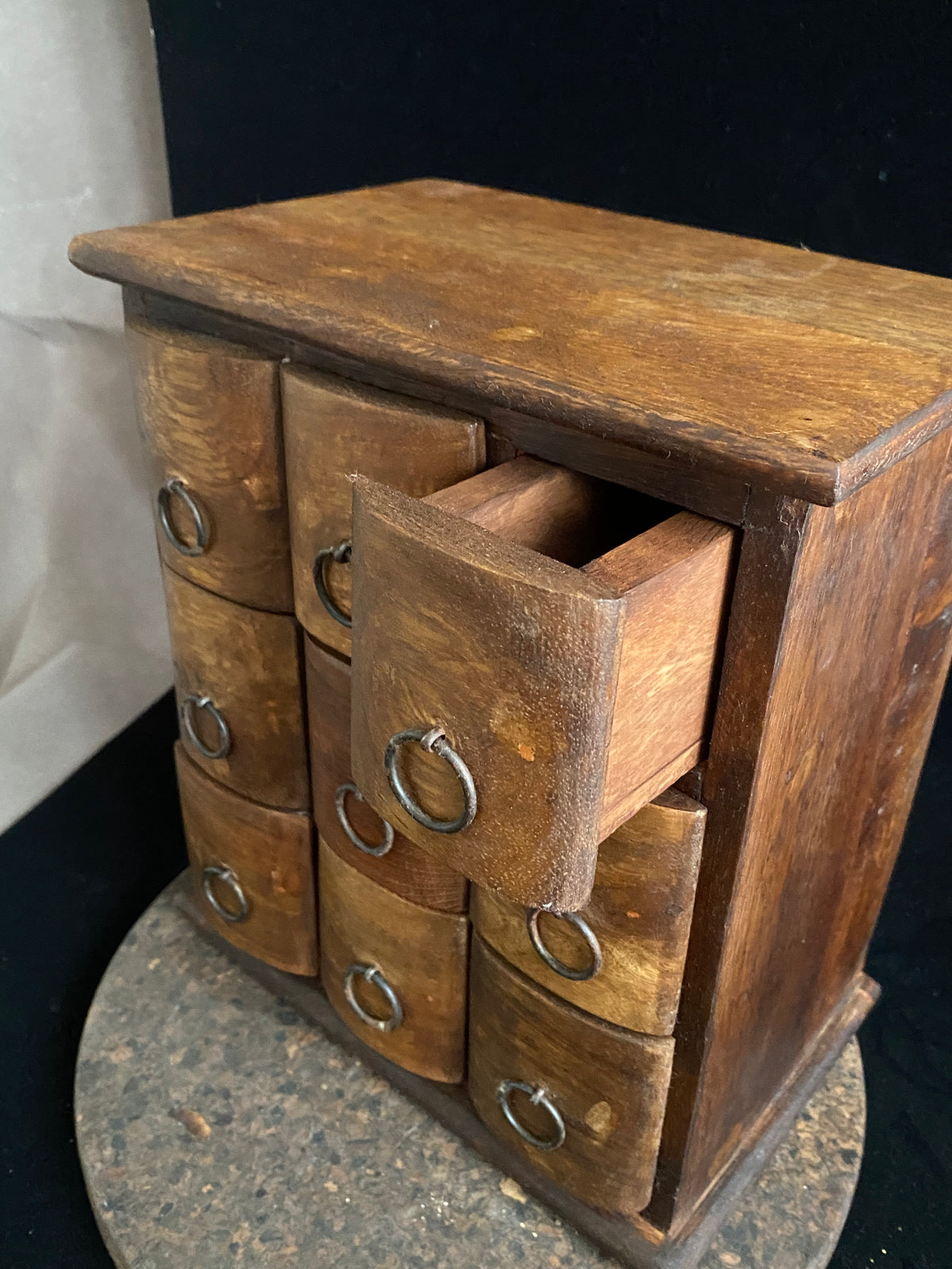 Simple curved face nine drawer cabinet trinket box. Made from solid Indian rosewood with iron rings as handles.  From Rajasthan, India. Made from Indian hard wood.  Height 28 cm, width 24.5 cm, depth 15.5 cm