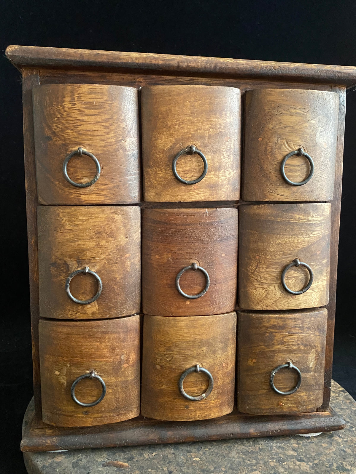 Simple curved face nine drawer cabinet trinket box. Made from solid Indian rosewood with iron rings as handles.  From Rajasthan, India. Made from Indian hard wood.  Height 28 cm, width 24.5 cm, depth 15.5 cm