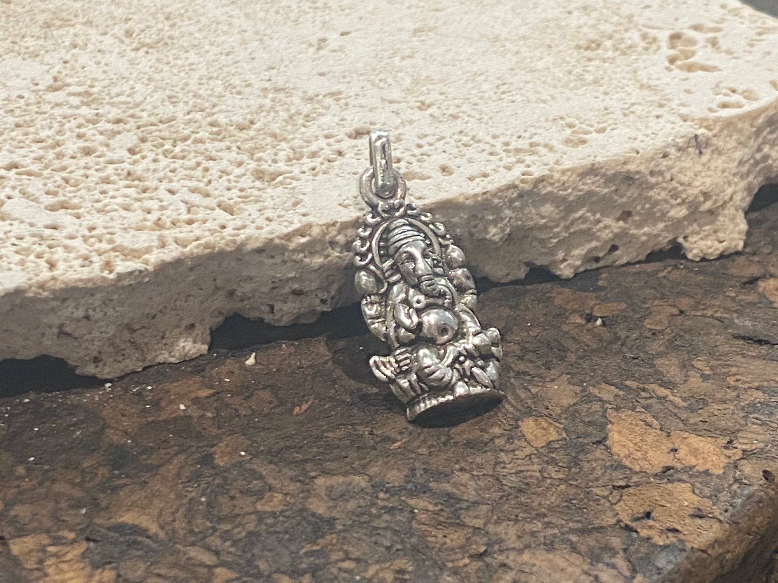 Sterling silver pendant featuring an elegant and finely detailed image of Lord Ganesha. A generous bail allows this pendant to be worn on a large chain or cord. This is a unisex pendant. Sterling silver, from India Measurements: 3 cm height including bail, width 1.2 cm