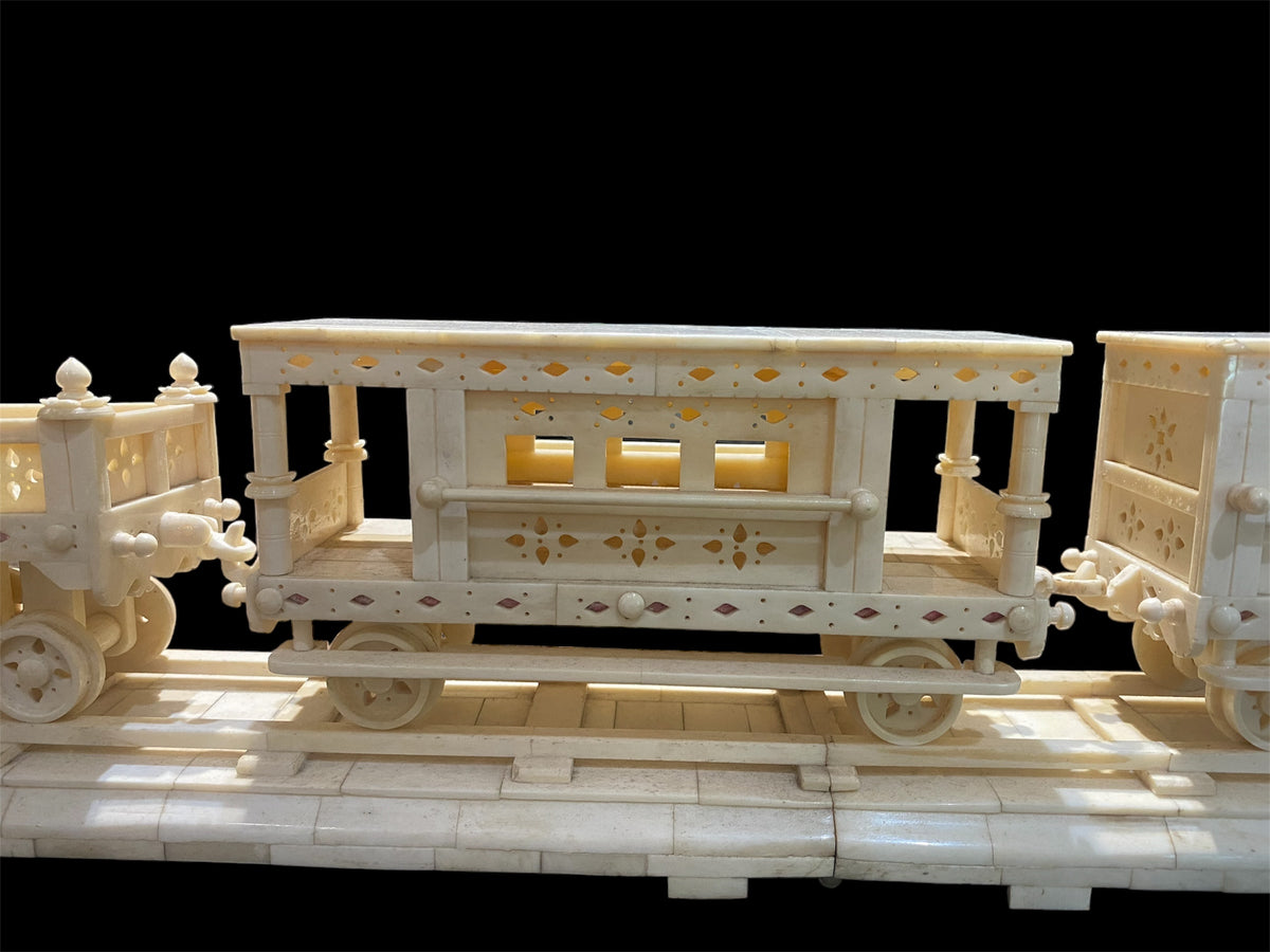 Large vintage train set handcrafted from finely shaped panels of camel bone. Northern India. Circa 1980. The set consists of four pieces: the track measuring 1.2 metres in length, the engine carriage with working pistons, the passenger carriage and the engineer's carriage.