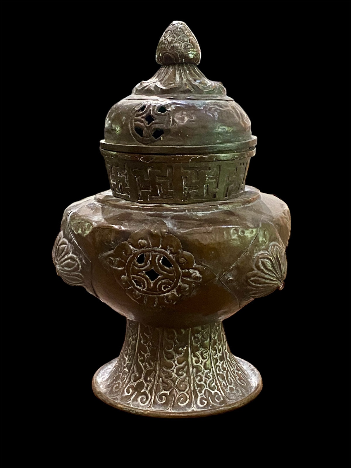 Handmade large incense burner. Pierced & footed pot with lid and inner tin to hold incense. Topped with lotus bud, ringed with viswa vajras, lotus buds, cloud spandrels and a frieze of swastikas. Hand beaten copper, mid 20th century. Collected by Bernard Heaphy in a village near Mount Everest. 31 cm h x 17 cm diameter