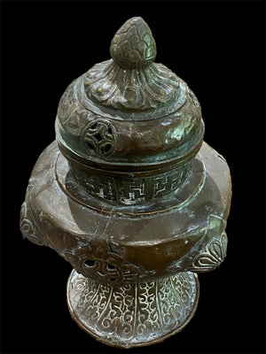 Handmade large incense burner. Pierced & footed pot with lid and inner tin to hold incense. Topped with lotus bud, ringed with viswa vajras, lotus buds, cloud spandrels and a frieze of swastikas. Hand beaten copper, mid 20th century. Collected by Bernard Heaphy in a village near Mount Everest. 31 cm h x 17 cm diameter