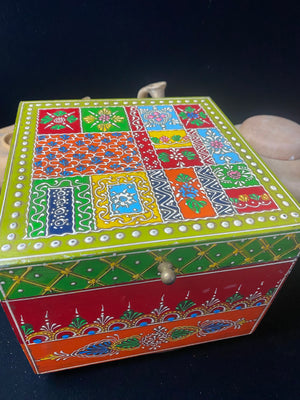 Large and vibrant hand painted trinket box. Small brass knob as handle. Perfect decorated box to keep your trinkets in. Its large roomy interior makes this a great box to hold essential oils or jewellery.  From Rajasthan, India.  Measurements: 20 x 20 cm, height 16 cm