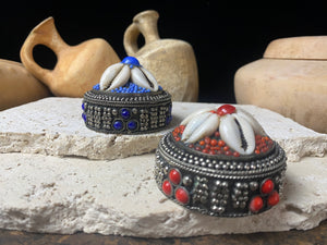 Small round pill or trinket boxes. Metal with bead and cowrie shell decoration. Tight fitting lid. Velvet lined, including inside the lid. These are perfect trinket boxes for kids, and would also make a very nice jewellery presentation box for gifting jewellery.  Measurements: 5.5 cm (2.25") diameter, height 5 cm (2")   