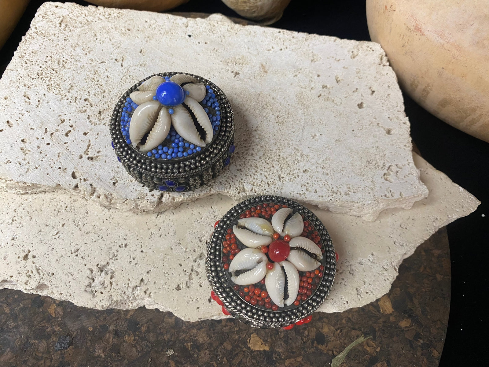Small round pill or trinket boxes. Metal with bead and cowrie shell decoration. Tight fitting lid. Velvet lined, including inside the lid. These are perfect trinket boxes for kids, and would also make a very nice jewellery presentation box for gifting jewellery.  Measurements: 5.5 cm (2.25") diameter, height 5 cm (2")   