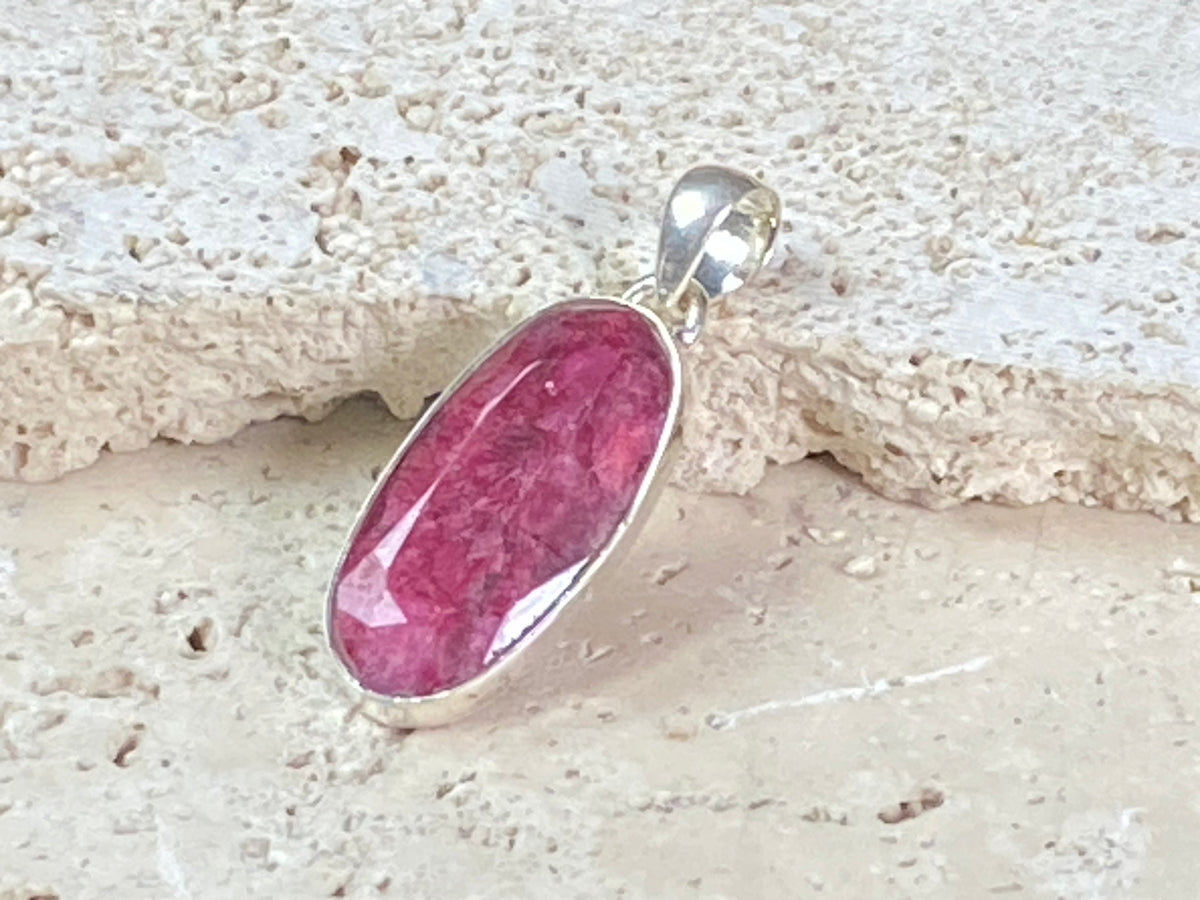 Natural ruby pendants featuring large facet cut stones set in sterling silver. All are set with generous bails to fit on even the largest of chains, torcs or cords. Ranging in length from 6 cm to 2.5 cm