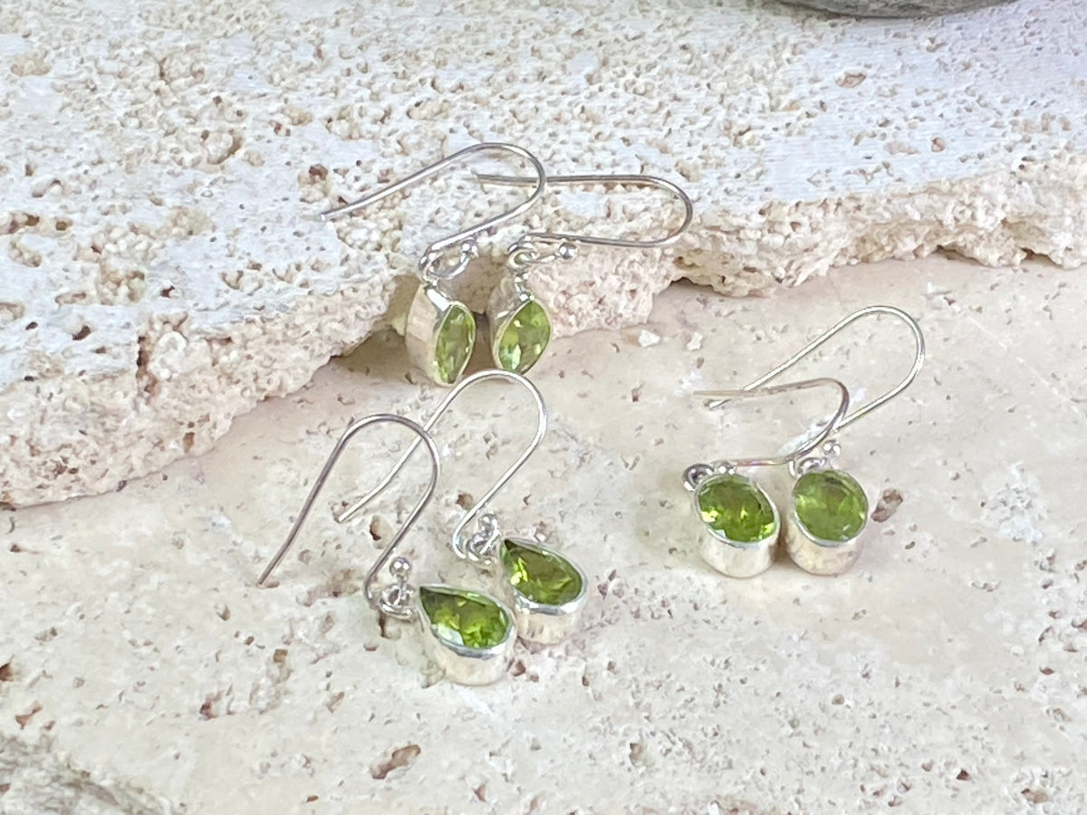 Beautiful peridot earrings featuring gem quality facet cut peridot stones in three shapes, teardrop, oval or leaf. A sterling silver mount and hook completes the look. These earrings are open at the back to allow light to shine through the stones. Around 3 cm length including hook