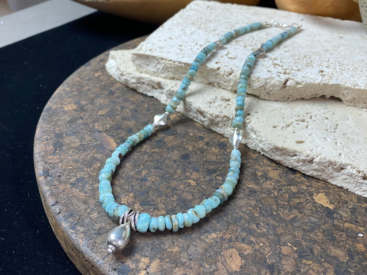 Light blue blue necklace of tumbled, facet cut graduated larimar, highlighted with Rajasthani silver beads and a beautiful central drop pendant. Finished with sterling silver findings and hook clasp. and a hook clasp. Measurements: 46 cm (18") length