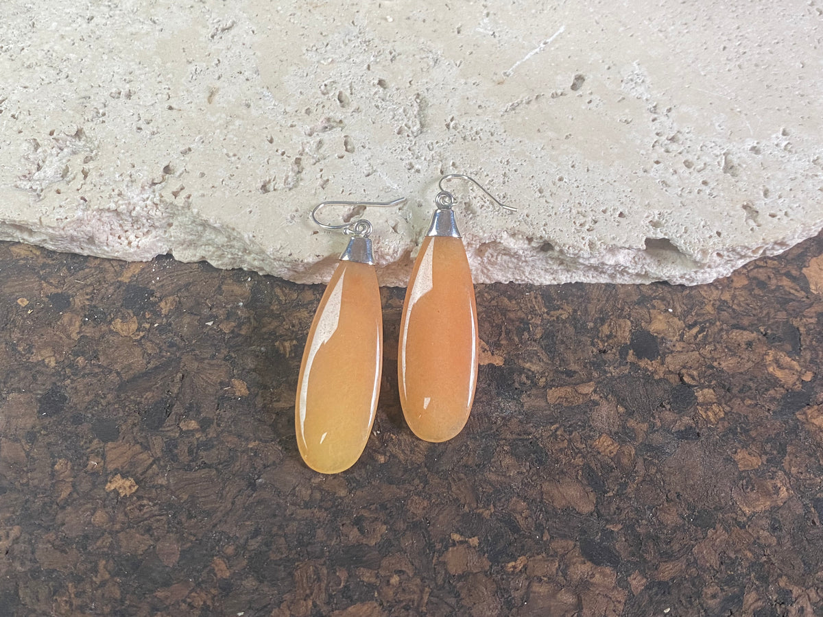 Translucent orange flat teardrop jade earrings set in stylish sterling silver mounts and hooks. Lightweight and easy to wear. 5 cm length including hook, width 1.2 cm at widest point 