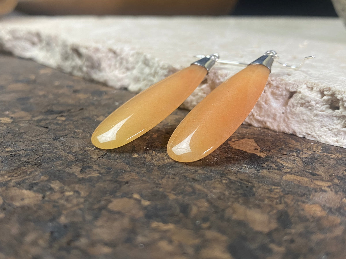 Translucent orange flat teardrop jade earrings set in stylish sterling silver mounts and hooks. Lightweight and easy to wear. 5 cm length including hook, width 1.2 cm at widest point 
