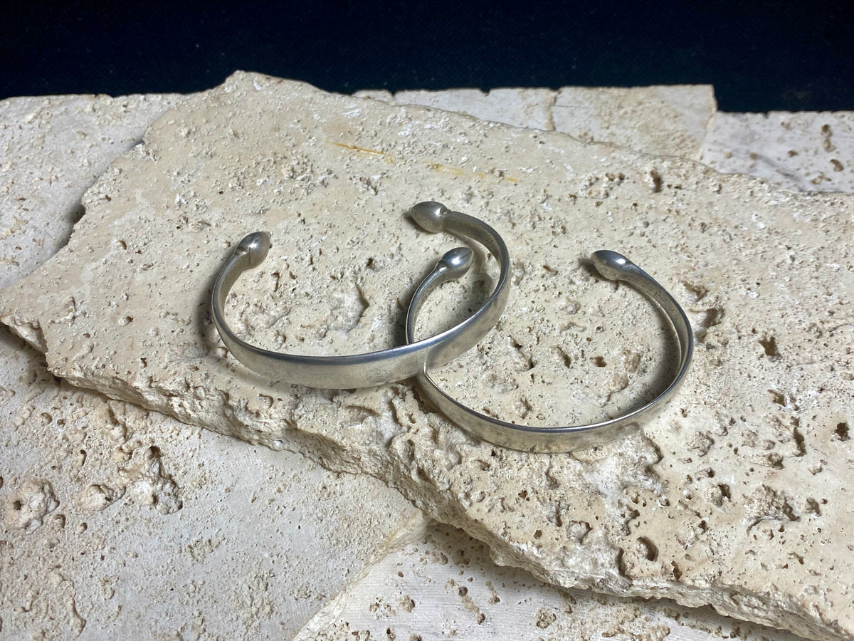 Indian antique silver bracelets, most likely made originally to be worn as a pair. These date to the early 1900's. They display a lovely worn and aged patina and test out at 80% silver. Measurements: height at front 1 cm